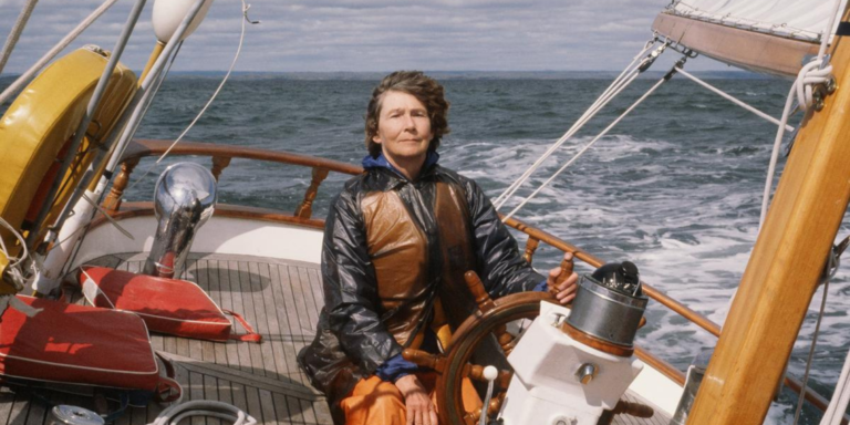 A woman drives a sailboat